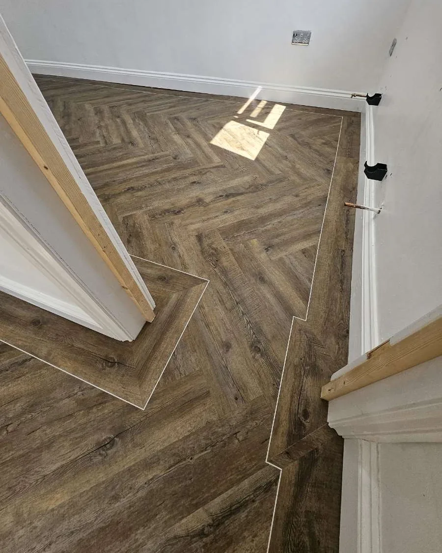 Herringbone LVT with a border strip around a doorway